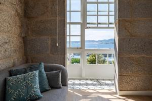uma sala de estar com um sofá e uma grande janela em Bow Homes by Como en Casa em Vigo