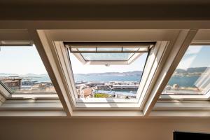 Cette chambre dispose de trois fenêtres offrant une vue sur l'eau. dans l'établissement Bow Homes by Como en Casa, à Vigo