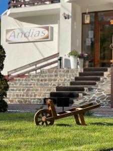 a bench sitting in the grass in front of a building at Pensiunea Andias in Suceviţa