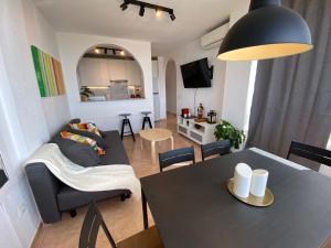ein Wohnzimmer mit einem Tisch und einem Sofa in der Unterkunft Apartamento DIORAMA D con impresionante vista, piscina y parking in Benalmádena