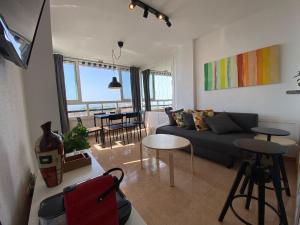 un soggiorno con divano e tavolo di Apartamento DIORAMA D con impresionante vista, piscina y parking a Benalmádena
