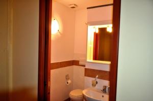 a bathroom with a sink and a toilet and a mirror at Casa MiLù in Canneto