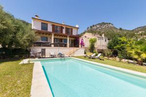 a villa with a swimming pool in front of a house at Sa Coma de Caimari in Caimari