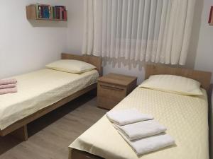 a bedroom with two beds and a window with towels at Apartment Tušek in Jadranovo