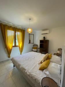 1 dormitorio con 1 cama con cortinas amarillas y vestidor en Gîte La Maison de Huguette et Lucien, en Le Vigan