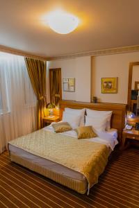 Un pat sau paturi într-o cameră la Hotel Ambasador Prishtina
