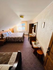ein Hotelzimmer mit einem Bett und einem Tisch in der Unterkunft Pensiunea Andias in Suceviţa
