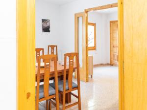 a dining room with a wooden table and chairs at Casa de l'Arbre in Aitona