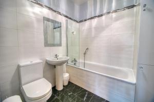 a white bathroom with a toilet and a sink at Royal Harbour Retreat - Balcony, sea view property in Ramsgate +10 photos