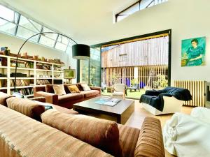 a living room with couches and a coffee table at VILLA LE LOFT - CALME & DECO - Patio intime - Salle de Cinéma - Centre Ville in Vannes