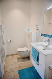 a white bathroom with a toilet and a sink at Le Clos des Fantaisies in Rivedoux-Plage