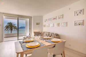 ein Esszimmer mit einem Tisch und Weingläsern in der Unterkunft Beachfront Apartment Sivella Mar in Port de Pollença
