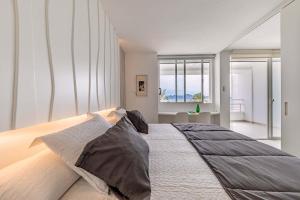 a bedroom with a large bed with two pillows on it at Beachfront Apartment Sivella Mar in Port de Pollensa