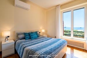 Un dormitorio con una cama y dos ventanas. en Giorgina Paraggi by PortofinoVip, en Portofino