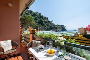 una mesa con un bol de fruta y vistas al océano en Giorgina Paraggi by PortofinoVip, en Portofino