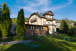 a large house with a playground in the yard at Milusia Muszyna in Muszyna