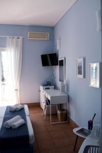 Mirtia Hotel في بيفكي: غرفة نوم بجدران زرقاء ومكتب وسرير