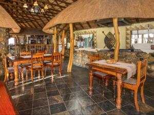 uma sala de jantar com mesas e cadeiras de madeira em Mkuze Falls Private Game Reserve em Mkuze