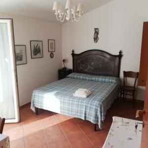 1 dormitorio con 1 cama con manta a cuadros en Casa vacanze Ex B&B La Bicocca - Via Umberto 15, en Sorso