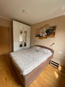 a bedroom with a bed and a flower on the wall at Apartman Milenium & SPA in Zlatibor
