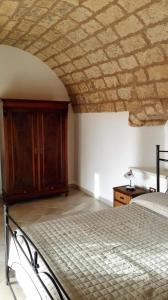 ein Schlafzimmer mit einem Bett und einer Steindecke in der Unterkunft Masseria Li Curti in Giuliano