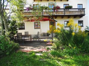 ein Haus mit einer Terrasse mit einem Tisch und einem Balkon in der Unterkunft Ferienhaus am Waginger See in Kirchanschöring