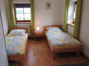 ein Schlafzimmer mit 2 Betten und einer Lampe in der Unterkunft Ferienhaus am Waginger See in Kirchanschöring