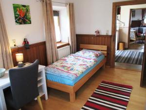 ein Schlafzimmer mit einem Bett, einem Tisch und einem Stuhl in der Unterkunft Ferienhaus am Waginger See in Kirchanschöring