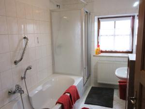 ein Badezimmer mit Badewanne und Waschbecken in der Unterkunft Ferienhaus am Waginger See in Kirchanschöring + 26 Fotos