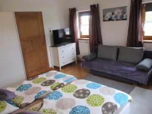 ein Wohnzimmer mit einem Bett und einem Sofa in der Unterkunft Ferienhaus am Waginger See in Kirchanschöring