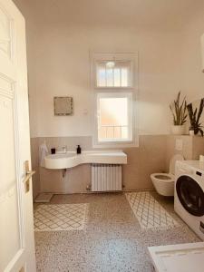 a bathroom with a sink and a toilet and a window at The Best Location salon apartment with main street view in Sarajevo