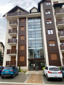 two cars parked in front of a building at Apartman Milenium & SPA in Zlatibor