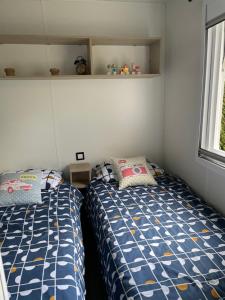 a bedroom with two beds and a window at Le mobilhome de Evelyne et Serge in Lit-et-Mixe