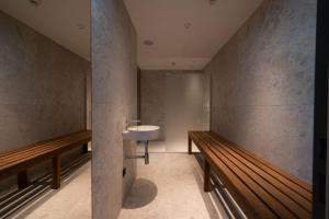 bagno con lavandino e panche in legno di Hotel Le Parc a Wiener Neustadt