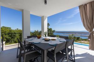 a dining room with a table and a view of the ocean at Villa Visum in Šmrika