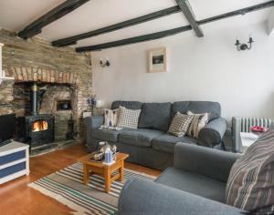 a living room with a couch and a fireplace at Cloam Cottage in Port Isaac