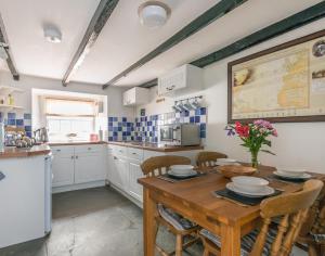 a kitchen with a wooden table with chairs and a tableasteryasteryasteryasteryastery at Cloam Cottage in Port Isaac