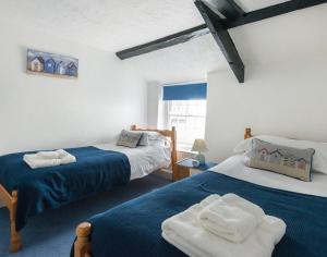 une chambre avec deux lits avec des serviettes dessus dans l'établissement Cloam Cottage, à Port Isaac