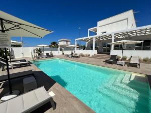 a swimming pool in front of a house at Elite Luxury Residence in Torre Suda