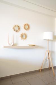 a white wall with three mirrors and a lamp at Apartamento frente al mar in Valencia