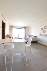 a dining room with white tables and white chairs at Apartamento frente al mar in Valencia