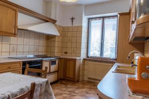 a kitchen with a sink and a stove and a window at Baita del me Remo, in the heart of Levico Terme in Levico Terme