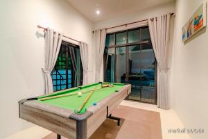 uma mesa de bilhar numa sala de estar com uma piscina em สโลไลฟ์ ปาร์ตี้ หัวหิน พูลวิลล่า Slowlife Party Hua-Hin Pool Villa em Hua Hin