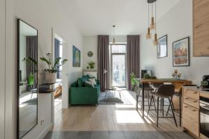 a kitchen and living room with a green couch at Apartament Księżycowy - Młyn Maria - Art Apartments in Wrocław
