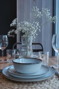 a table with a plate and a vase of flowers at Modern apartment in Henningsvær in Lyngværet