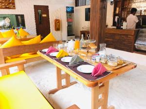 una mesa de madera con platos de comida. en Atholhu Residence, en Fehendhoo