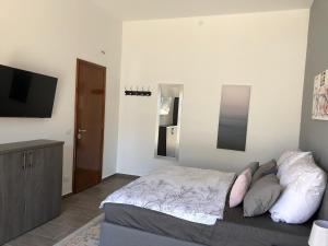 1 dormitorio con 1 cama y TV de pantalla plana en Casa-Riposto, en Riposto