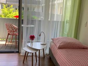 ein Schlafzimmer mit einem Bett, einem Tisch und einem Stuhl in der Unterkunft Ferienwohnungen Wolke in Regensburg