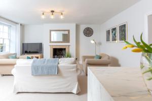 a living room with white furniture and a fireplace at 32 Evesham Road - By Luxury Apartment in Cheltenham