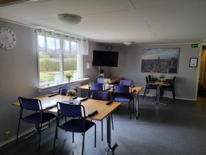 a meeting room with tables and chairs and a tv at Nyckelbo Vandrarhem in Helsingborg
